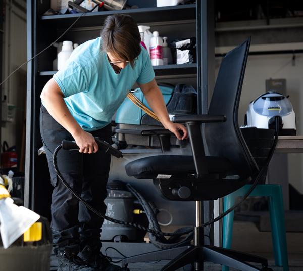 techniceinne en train de shampouiner un fauteuil de bureau